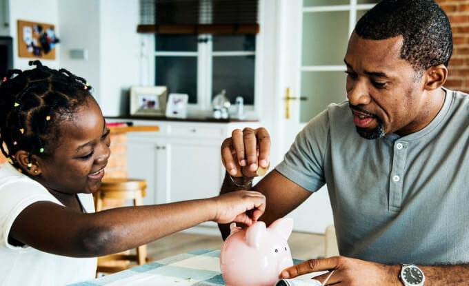 Father and Daughter with Piggy Bank